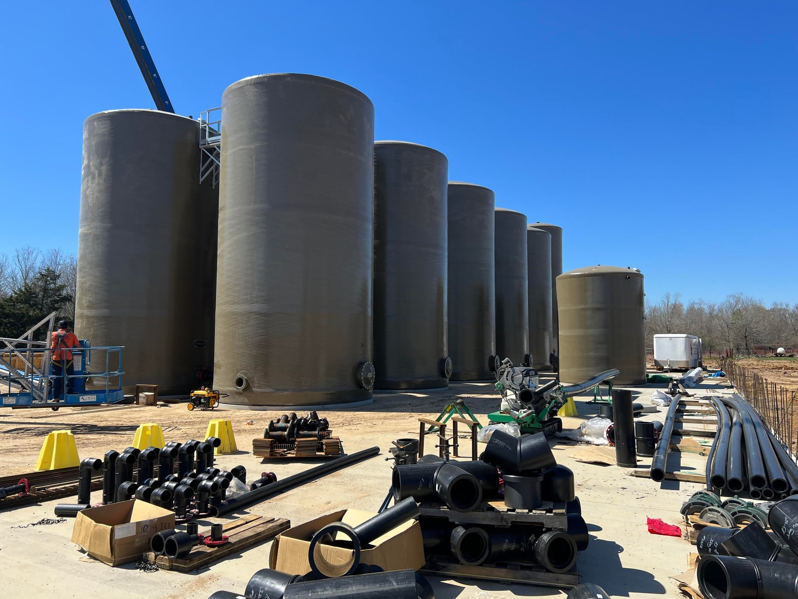 Row of tanks with a worker on a lift